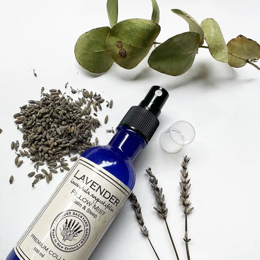 Close-up view of lavender sleep spray scented with essential oil, surrounded by dried lavender flowers, lavender rubbings, and eucalyptus leaves, emphasizing its calming and aromatic properties.
