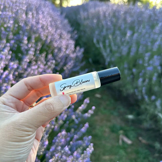 Spring Blossom Essential Oil Roller Blend, displayed with a fresh floral background at Lavender Backyard Garden, NZ.