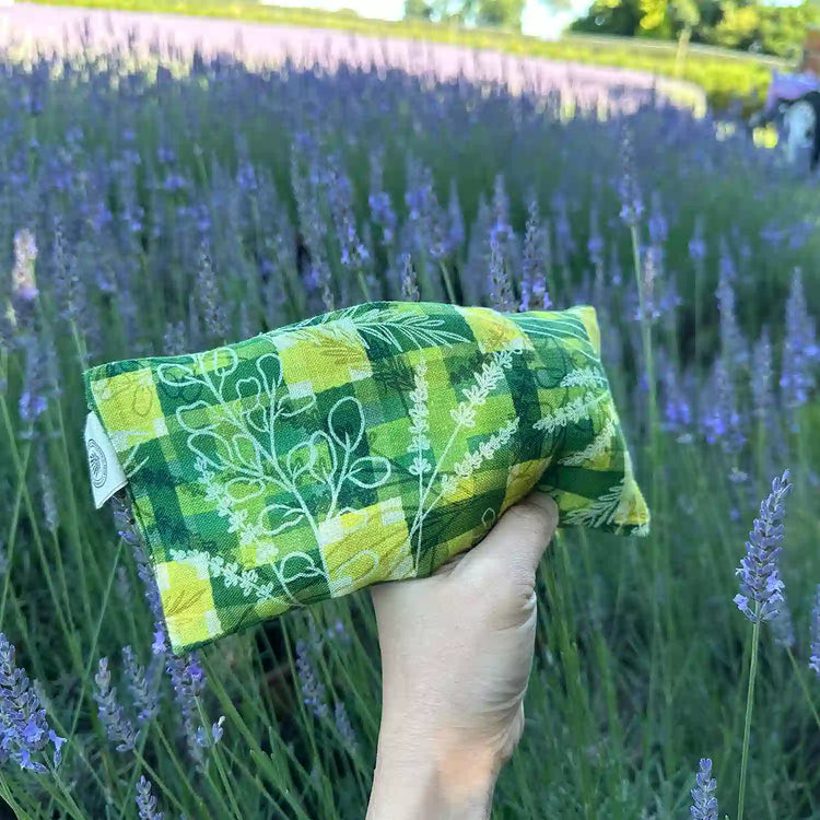 Green pattern lavender eye pillow filled with flaxseed and lavender flower buds, set against our lavender field