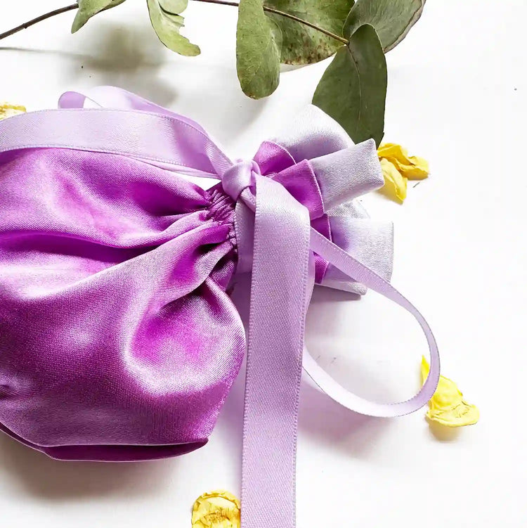 Close-up of a satin lavender sachet bag for drawers and closets, with eucalyptus leaves and rose petals