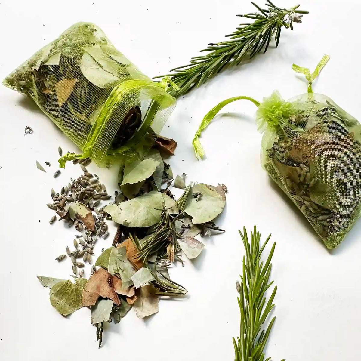 Eucalyptus, rosemary, and lavender herb sachet for drawers or closets, with a close-up view of herbs spread around the sachets.